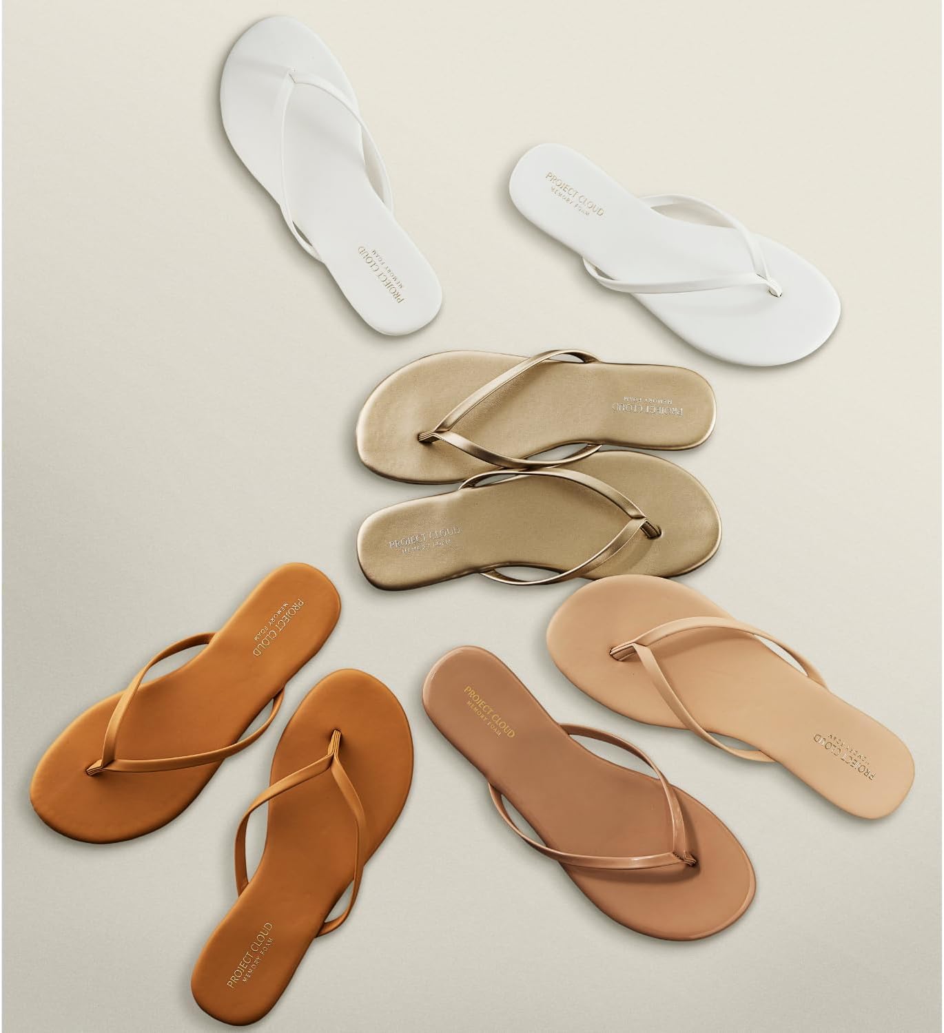 Neutral memory foam flip flops for women with non-slip soles, shown from the side on a sandy beach background โ back